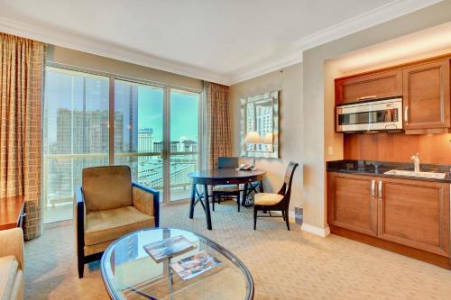 a living room with a kitchen and a dining room at Strip View Balcony Suites - No Resort Fee ! in Las Vegas