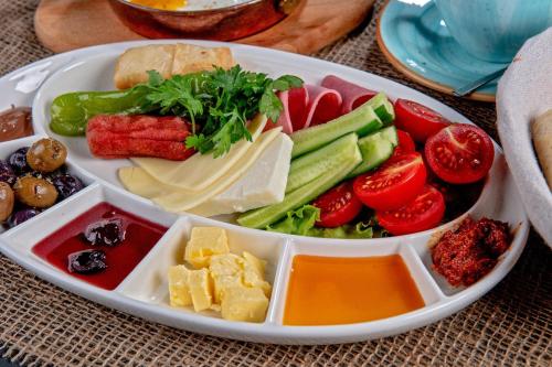 una bandeja de comida con verduras y queso en una mesa en La Rezidans Hotel en Antalya