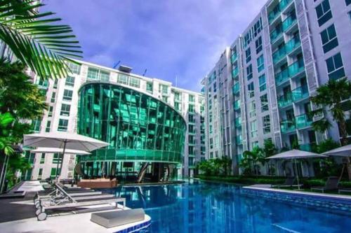 a swimming pool in front of a large building at City Center Residence - Pool view in Pattaya Central