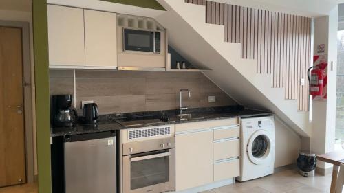 a kitchen with a washer and dryer under a staircase at Miras Apartment Ushuaia in Ushuaia