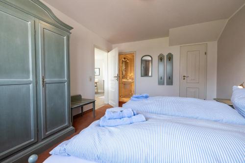 a bedroom with two beds with towels on them at Haus Amanda in Norddorf