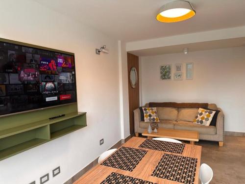 een woonkamer met een bank en een flatscreen-tv bij Miras Apartment Ushuaia in Ushuaia