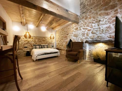 - une chambre avec un lit et un mur en pierre dans l'établissement Casa Orama Slow Living, à Archanes