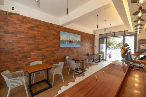 a restaurant with tables and chairs and a brick wall at Hotel Lourdes, Siaya in Siaya