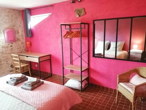 Cette chambre est dotée d'un mur rose avec un lit et un miroir. dans l'établissement Moulin de la Passere, à Eus