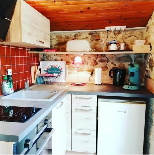 une petite cuisine avec un évier et une lampe dans l'établissement Moulin de la Passere, à Eus