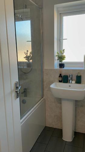 a bathroom with a sink and a shower and a toilet at Luxury Rooms in a 3-Bedroom House, Living Room, Kitchen, Big garden only 8mins away from Coventry City Centre in Coventry