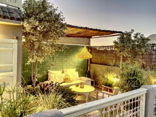 a patio with a couch and a table in a garden at Riad Dar Chacha in Marrakech