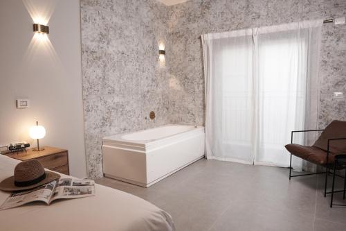a bedroom with a tub and a bed and a window at 49 Boutique in Zikhron Ya‘aqov