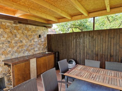 an outdoor patio with a wooden table and chairs at Relax Vila se zahradním wellness in Ostrava