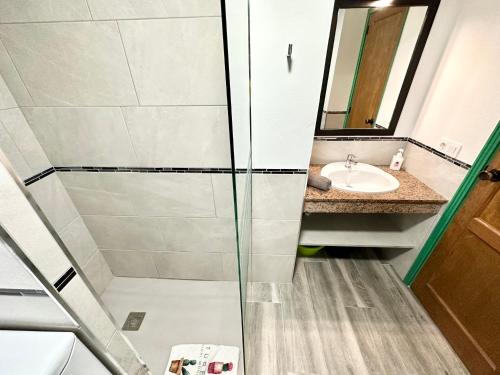 une salle de bain avec douche et lavabo dans l'établissement Kiwi Smoothie - En la playa, doble terraza, cocina completa, dos camas y Wifi, à El Cotillo