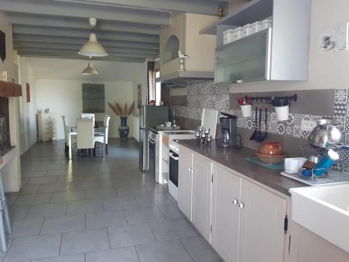 a large kitchen with white cabinets and a table at Maison de campagne 10 personnes. in Brizambourg
