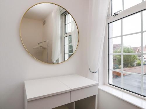 a white bathroom with a mirror and a window at Kitty Cottage in Blackpool