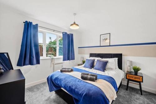 a bedroom with blue curtains and a large bed at Beautiful Lincoln Abode - Sleeps 6 - Parking in Lincoln