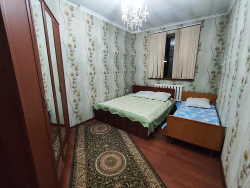 a small bedroom with two beds and a window at 5-комнатный дом посуточно in Shymkent