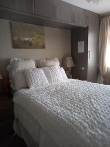 1 dormitorio con 1 cama grande con sábanas blancas en The Boat House BED ONLY NO BREAKFAST, en Aultbea