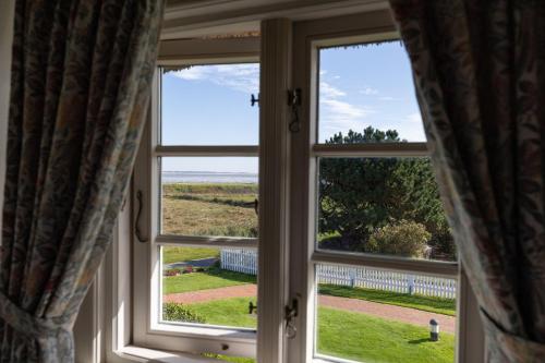 a window with a view of the ocean at Haus Amanda in Norddorf