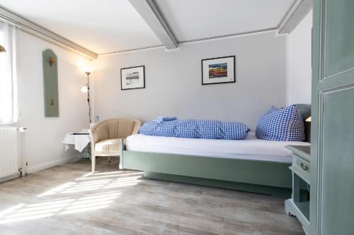 a bedroom with a bed with blue pillows and a table at Haus Amanda in Norddorf