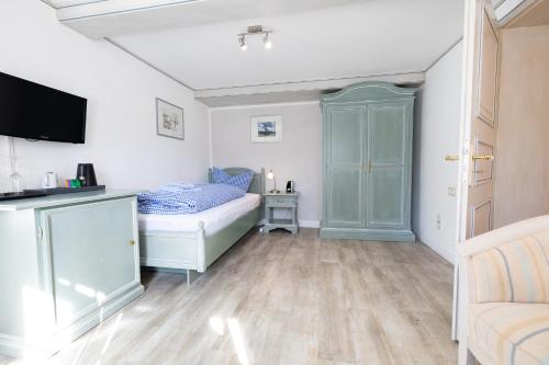 a small bedroom with a bed and a tv at Haus Amanda in Norddorf