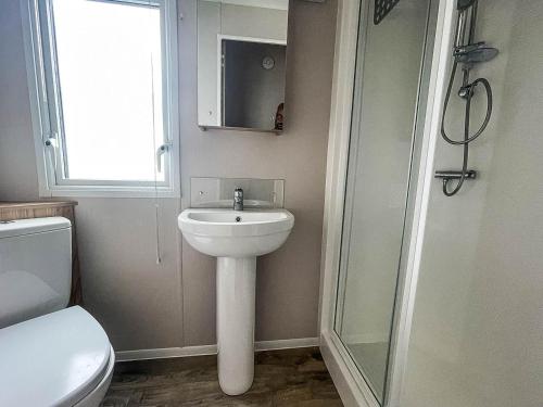 ein Bad mit einem Waschbecken, einem WC und einer Dusche in der Unterkunft Beautiful 6 Berth Caravan With Decking, Wifi And Field Views Ref 29029sv in Clacton-on-Sea