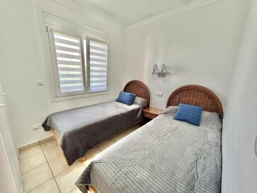 1 dormitorio con 2 camas y almohadas azules en Apartamento Teresa en Oliva