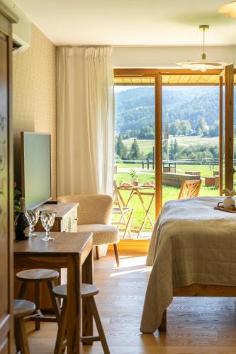 a bedroom with a bed and a table and a window at Apartamenty Zana by Apart Concept Podhale in Kościelisko