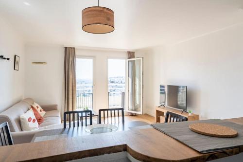 a living room with a table and a couch at Paris la Défense, lumineux et cosy in Courbevoie