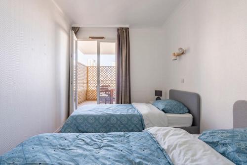 Cet appartement comprend une chambre avec deux lits et un balcon. dans l'établissement Paris la Défense, lumineux et cosy, à Courbevoie