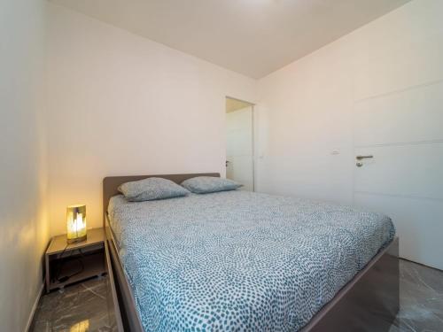 une chambre avec un lit dans une pièce blanche dans l'établissement Appartement T3 climatisé, Wi-Fi, à Marseille