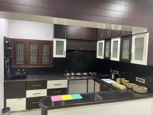 een keuken met bruine kasten en een zwart aanrecht bij Atithi Homestay in Tirupati
