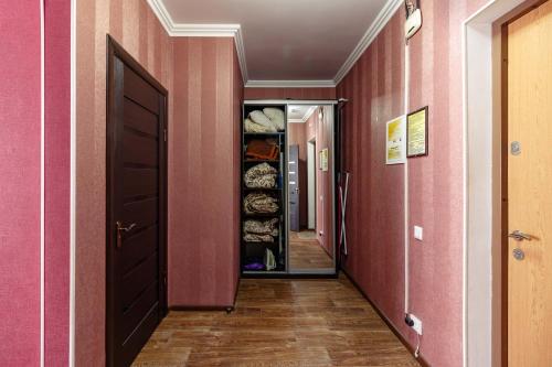 ein Flur mit rosa Wänden und einem Schrank in der Unterkunft Kvartirkoff na Bogatyrskaya 6a, 15th floor in Kiew