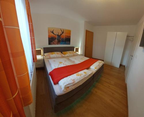 Un dormitorio con una cama con una manta roja. en Appartement Tamara, en Ramsau im Zillertal