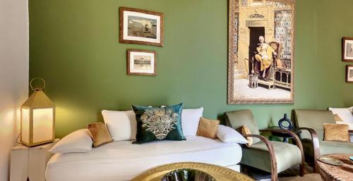 a bedroom with a green wall with a bed in it at Riad Dar Chacha in Marrakech
