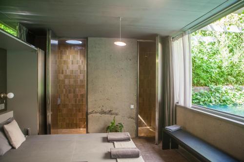 a bedroom with a bed and a window with towels at Fàbrica Descals and Pavillion in Olot