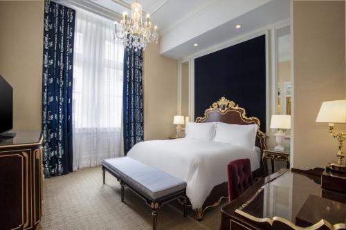 a bedroom with a large white bed and a chandelier at Waldorf Astoria Washington DC in Washington