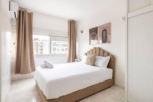 Un dormitorio blanco con una cama grande y una ventana en Charmant & Spacieux 2Chambres-5 min Gare Agdal en Rabat