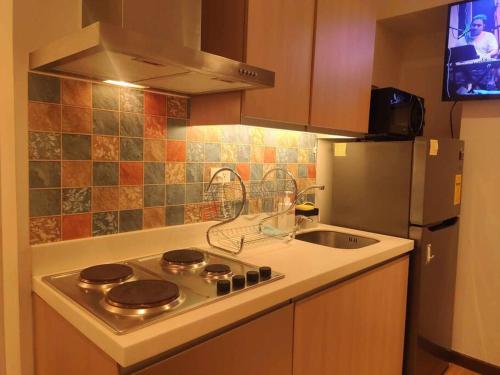 y cocina con fogones, fregadero y nevera. en Resort Living 2BR Azure Urban Residences w/ Wi-Fi en Parañaque