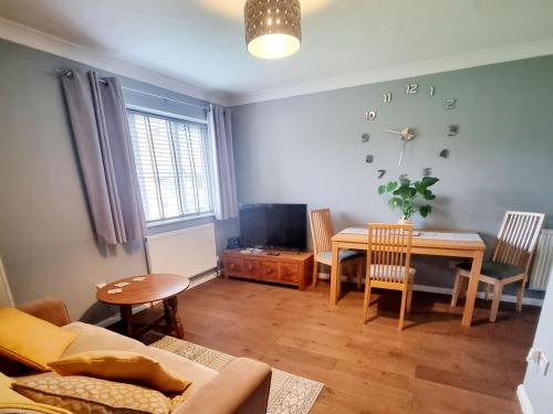 a living room with a couch and a dining room table at Private one bedroom apartment with garden and parking in Thame