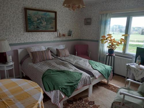 a bedroom with a bed with green sheets and a window at Vaskio-bed in Salo