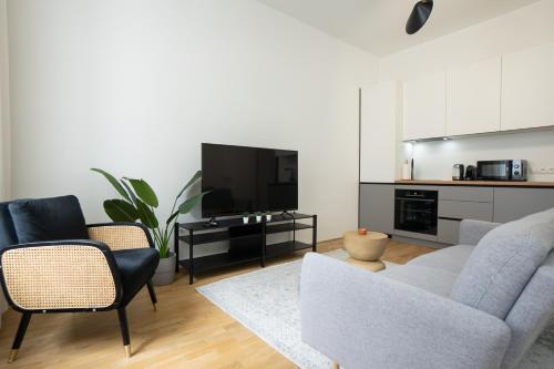 sala de estar con sofá, sillas y TV en Modern apartment in a top location of Vienna en Viena