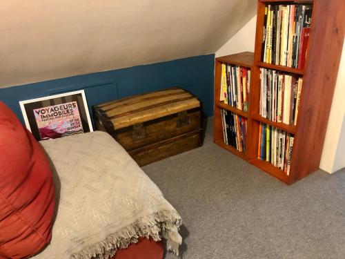 a bedroom with a bed and a wooden book shelf at Chambre double avec salle de bain privative in Auxerre