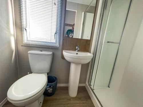 a bathroom with a toilet and a sink and a shower at Modern 8 Berth Caravan With Decking At Valley Farm, Essex Ref 46575v in Great Clacton