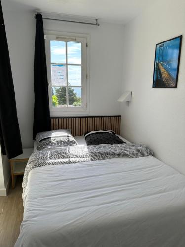 uma cama num quarto com uma janela em cap esterel em Agay - Saint-Raphaël