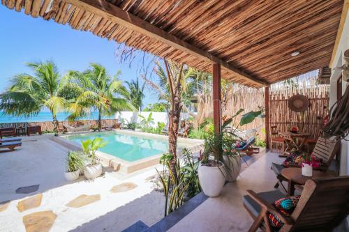 an outdoor patio with a swimming pool and palm trees at Babu Villas in Jambiani