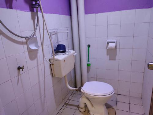 La salle de bains est pourvue d'une douche et de toilettes. dans l'établissement Home Sweet Home, à Kuching