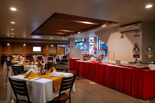 un restaurant avec des tables, des chaises et des nappes rouges dans l'établissement VICTORIA COMFORT INN, à Kisumu