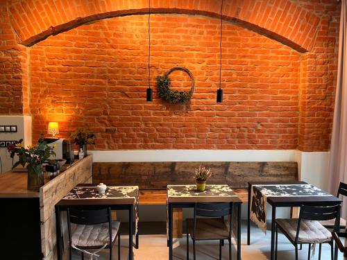 a room with two tables and a brick wall at CARLS AUTHENTIC B&B in Karlovy Vary