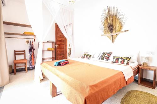 a bedroom with two beds and a chair at Babu Villas in Jambiani