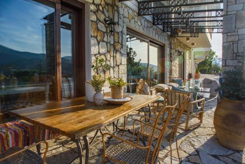 a wooden table and chairs on a patio at Archontiko Zafeiropoulou in Kalavrita