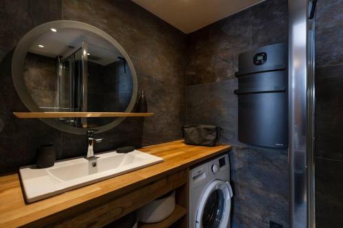 une salle de bain avec un lavabo et une machine à laver dans l'établissement Le Refuge du Lyret - 2 Pers - Rénové, à Chamonix-Mont-Blanc